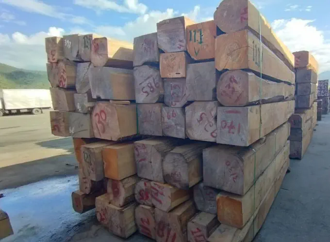 A photograph of stacks of rough sawn squares laying outside