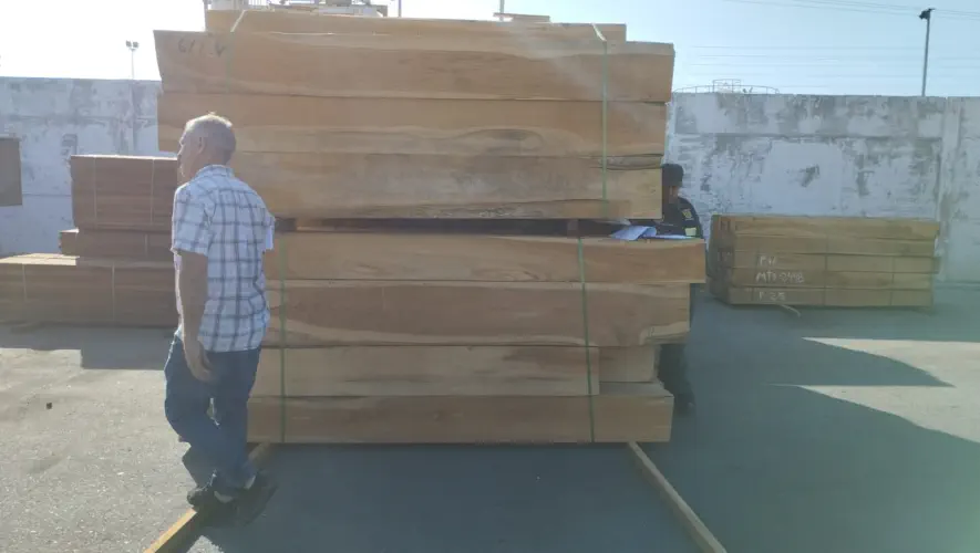 A photograph of stacks of rough sawn squares laying outside