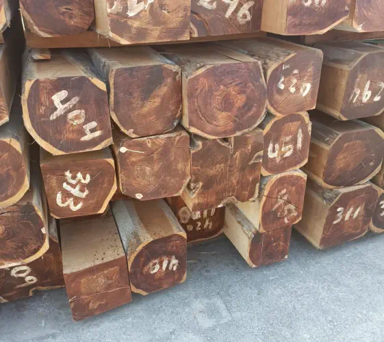 A photograph of stacks of rough sawn squares laying outside