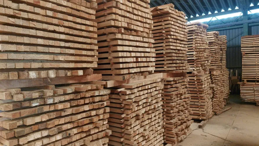 A photograph of stacks of balsa sawn tropical timber in a storage room