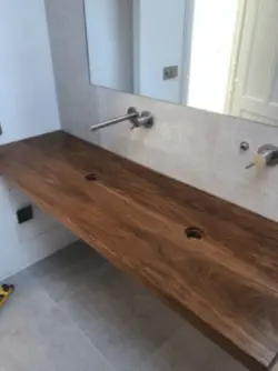 A photograph of oiled teak that is placed in a bathroom which is under construction